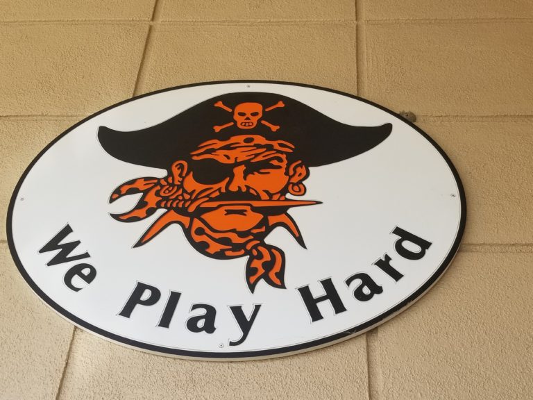 Photo of illustration with pirate and the text "We play hard"