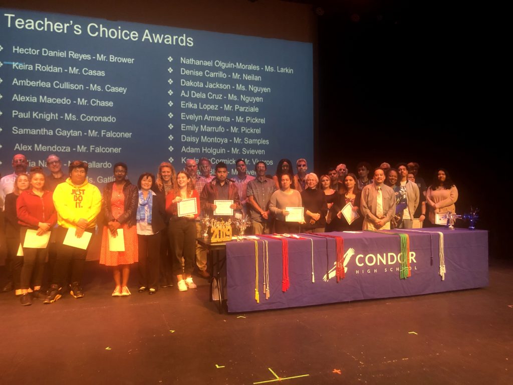 People are standing with certificates on the scene of Teacher's Choice Awards