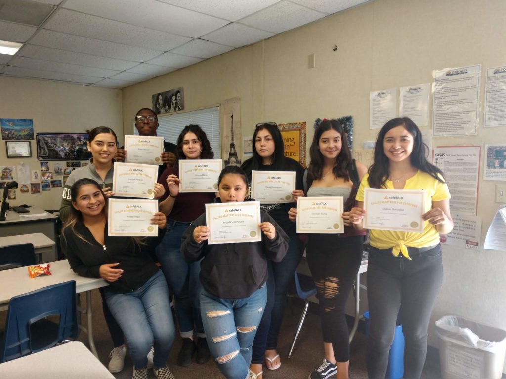 Teenagers are standing with certificates of safeTALK