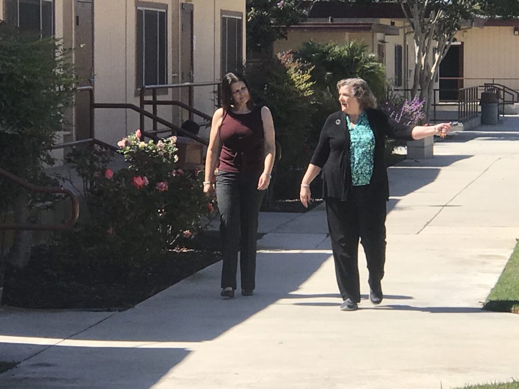 Two women are walking by the street