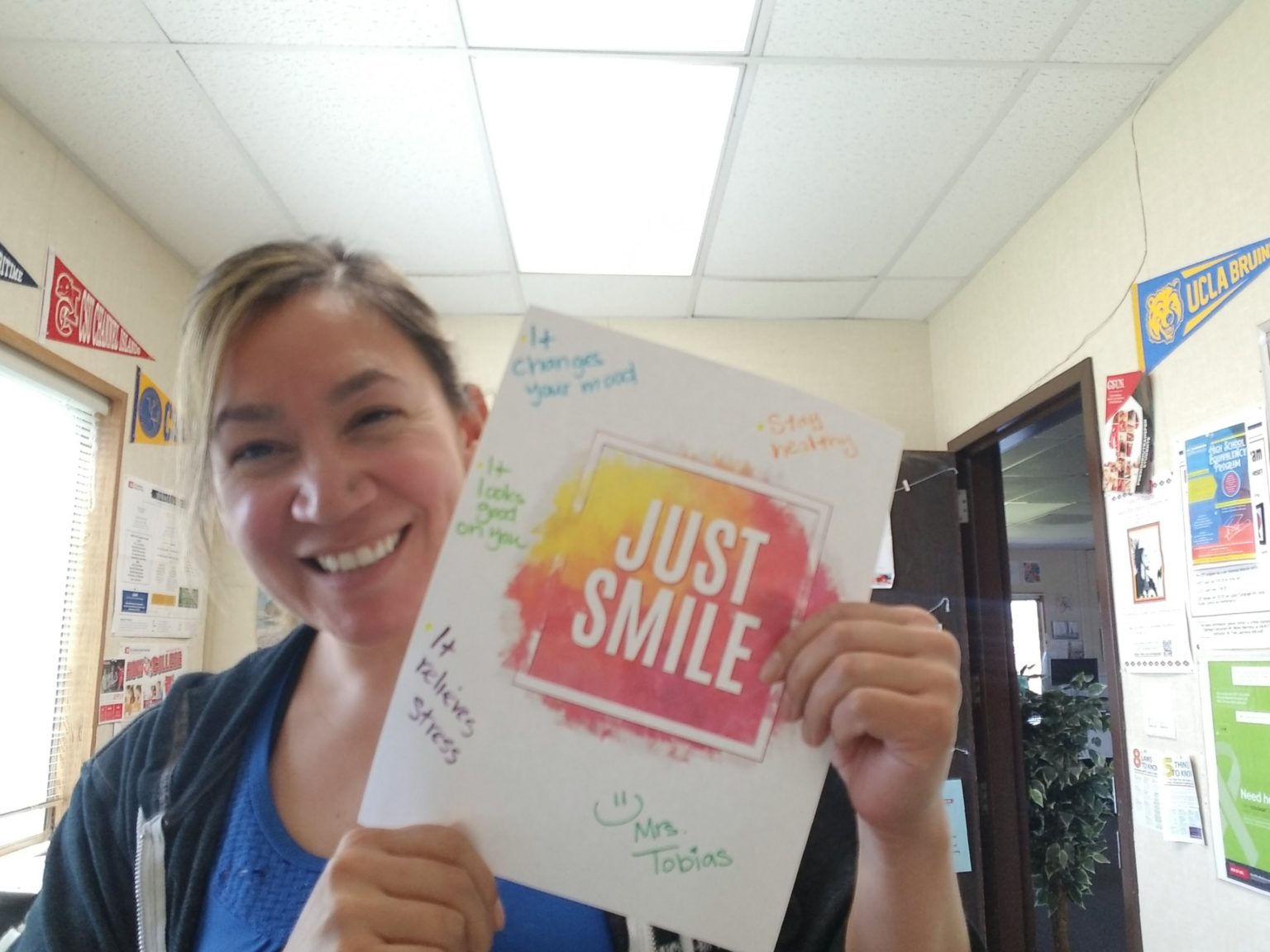 Mrs. Tobias holding paper with Just Smile written