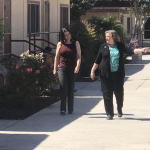 Two women are walking by the street